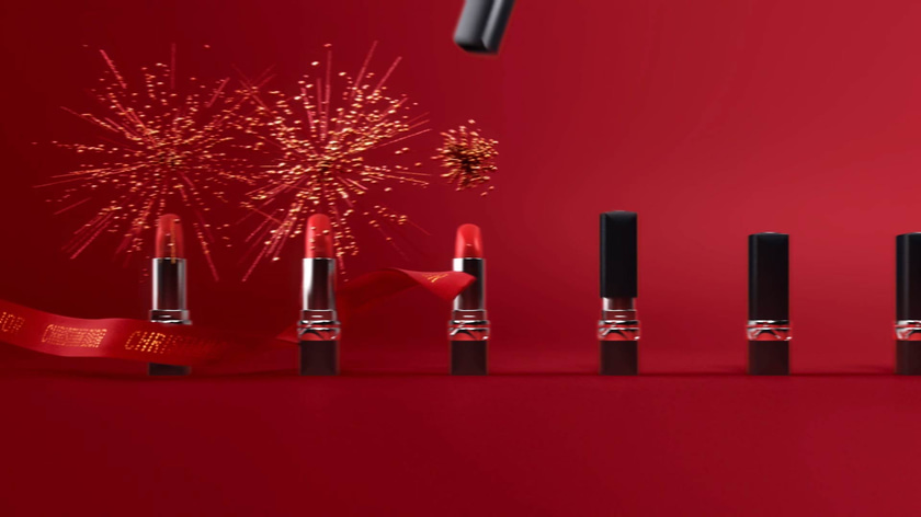 3D motion design with golden particles around Dior Rouges with ribbons